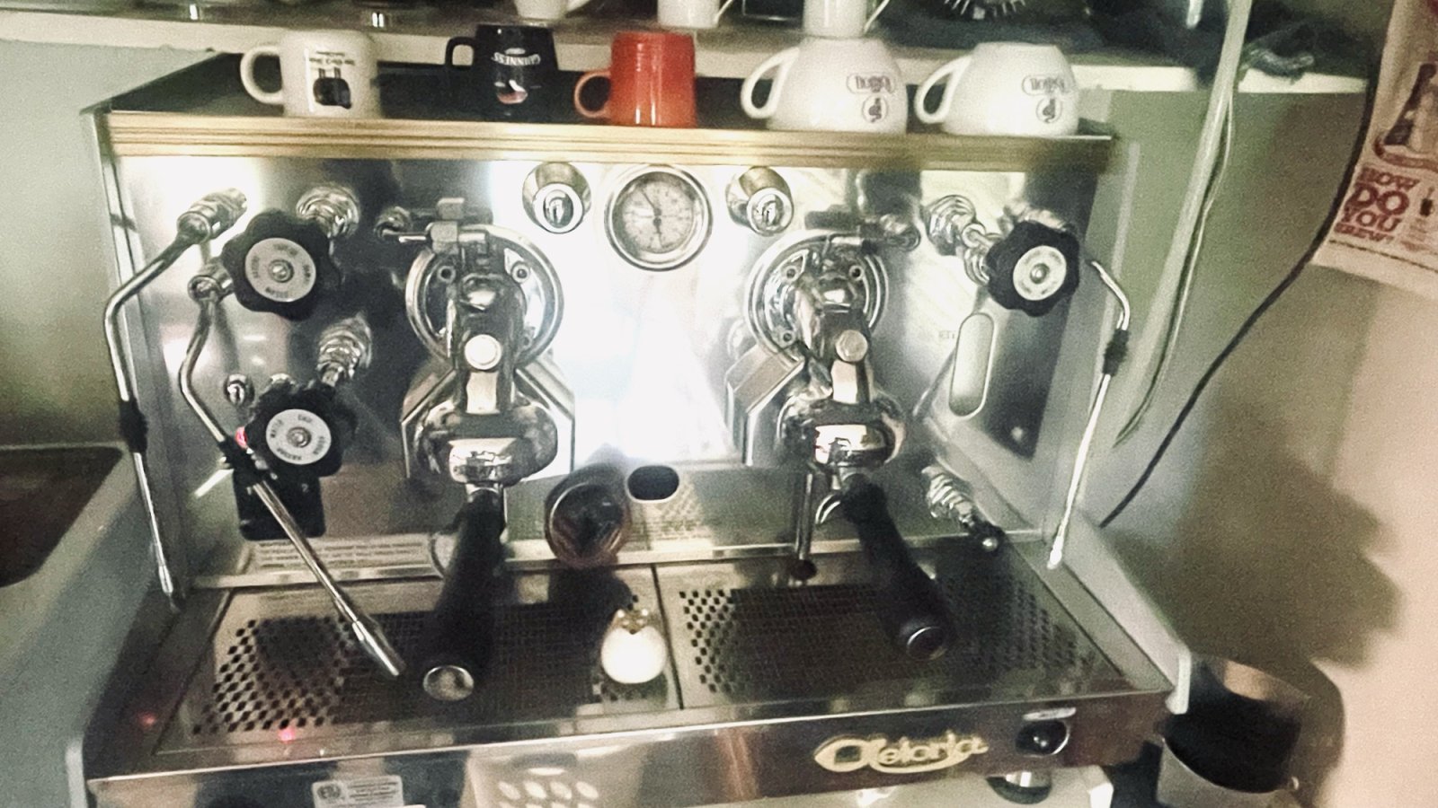 Espresso machine with a Japanese tea pet figurine, sitting on the tray where the cups go