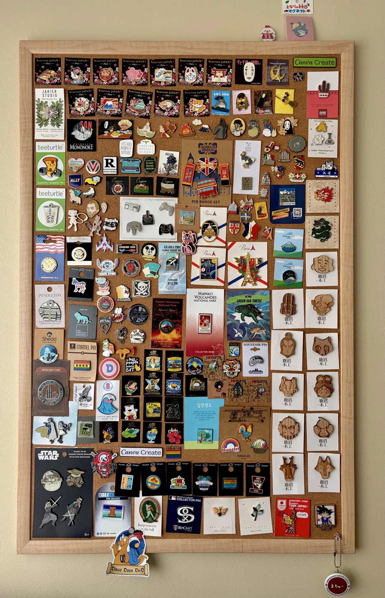 A cork board with 100+ enamel pins .