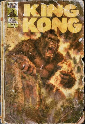 Giant ape looms over city holding woman in his hand. cover for King Kong book